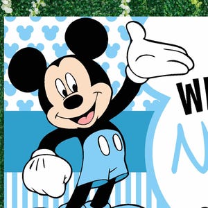 May include: A blue and white welcome sign featuring a cartoon image of Mickey Mouse wearing blue shorts and waving. The text on the sign reads "Welcome"