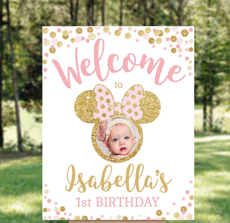 Pu&ograve; includere: Benvenuti al cartello del 1&deg; compleanno di Isabella con coriandoli glitter rosa e oro e una foto di una bambina con un vestito rosa e bianco.
