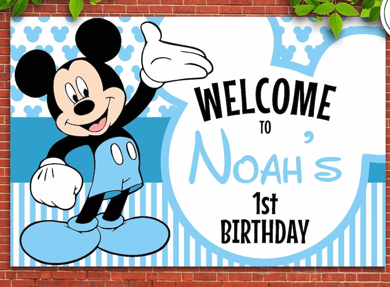 May include: A blue and white welcome sign featuring Mickey Mouse. The sign reads "Welcome to Noah's 1st Birthday".