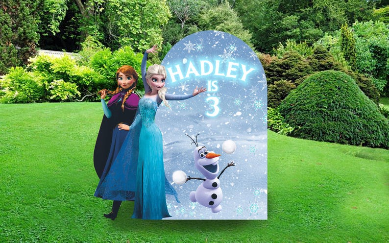 May include: A blue and white Frozen themed birthday party backdrop with a cutout of Elsa and Anna. The backdrop features a snowy scene with Olaf and the text "HADLEY IS 3".