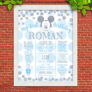 K&ouml;nnte beinhalten: Ein blaues und silbernes Poster zum ersten Geburtstag mit Mickey Mouse. Das Poster enth&auml;lt den Namen des Kindes, Roman, und Details zu seinem ersten Jahr, darunter sein Geburtsdatum, sein Gewicht, seine Gr&ouml;&szlig;e, seine Lieblingsessen, Lieder und B&uuml;cher.