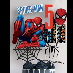 May include: Spider-Man cake topper featuring a red and blue Spider-Man figure, a black spider web, a black spider, and a cityscape with the number 5. The text "Spider-Man" is written in red letters.