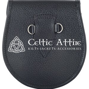 Puede incluir: Sporran de cuero negro con una hebilla plateada y un dise&ntilde;o de nudo celta. El sporran tiene el texto "Celtic Attire Kilts-Jackets-Accessories" impreso en &eacute;l.
