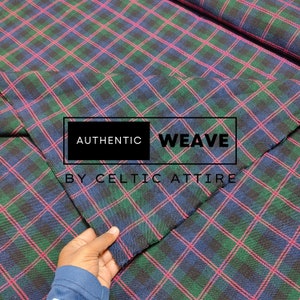 Könnte beinhalten: Nahaufnahme eines blauen, grünen und pinkfarbenen karierten Stoffes. Der Stoff ist in der Mitte gefaltet und der Text "AUTHENTIC WEAVE BY CELTIC ATTIRE" ist auf den Stoff gedruckt.