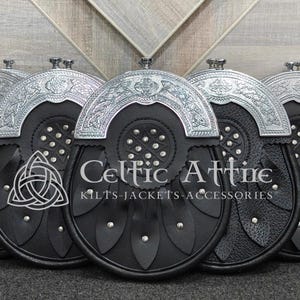 Pu&ograve; includere: Una collezione di sporran in pelle nera con dettagli in metallo argentato. Ogni sporran presenta un lembo decorativo, dettagli borchiati e un emblema a nodo celtico. Il testo "Celtic Attire" &egrave; visibile sul davanti.
