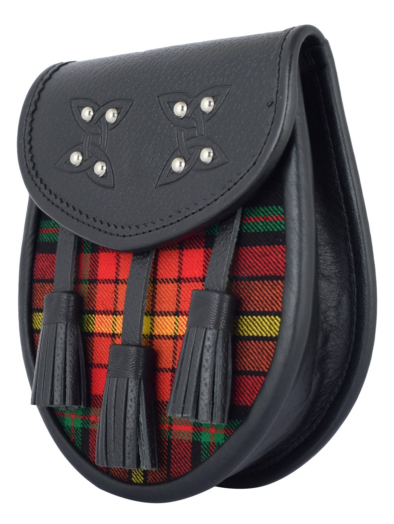 May include: A black leather sporran with a red, yellow, and green tartan flap and three black tassels. The sporran has two Celtic knot designs with silver studs.