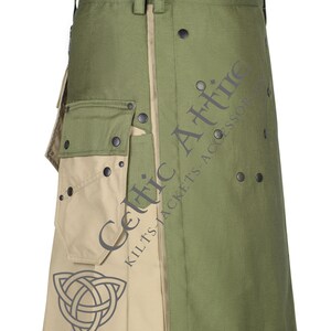 Op de afbeelding: Een groene en beige utility kilt met een grote cargozak en een Keltisch knoopontwerp. De kilt heeft een zwarte knoopsluiting en is gemaakt van een duurzame stof.