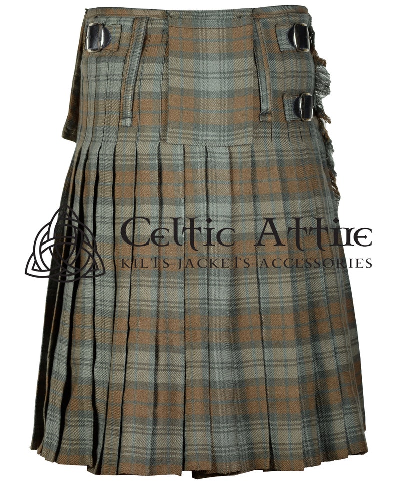 May include: A brown and green plaid kilt with black leather straps and buckles. The kilt is pleated and has a fringed edge. The text "Celtic Attire Kilts-Jackets-Accessories" is printed on the kilt.