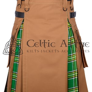 May include: A brown utility kilt with a green, yellow, and white tartan panel on the side. The kilt has a black leather belt with buckles and D-rings. The kilt is made of a durable, water-resistant fabric.