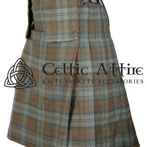 May include: A brown and green plaid kilt with pleats and a belt. The kilt is made of a woven fabric and has a traditional Scottish design. The text "Celtic Attire Kilts-Jackets-Accessories" is printed on the kilt.