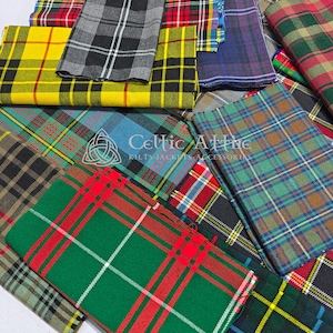 Può includere: Una collezione di campioni di tessuto tartan piegati in vari colori e motivi. I tessuti includono quadri gialli, verdi, rossi, blu e neri. L'immagine mostra anche il testo "Celtic Attire Kilts Jackets Accessories".