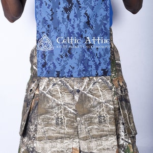 K&ouml;nnte beinhalten: Ein Tarnkilt mit einem blauen und schwarzen digitalen Tarnmuster-Klappen. Der Kilt tr&auml;gt das Celtic Attire Logo mit dem Text "Kilts Jackets Accessories".
