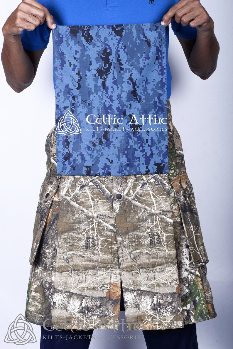 K&ouml;nnte beinhalten: Ein Tarnkilt mit einem blauen und schwarzen digitalen Tarnmuster-Klappen. Der Kilt tr&auml;gt das Celtic Attire Logo mit dem Text "Kilts Jackets Accessories".