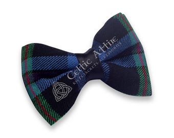 May include: A plaid bow tie in navy blue, green, and red. The bow tie has the text "Celtic Attire" and a Celtic knot symbol. The bow tie is a classic accessory.