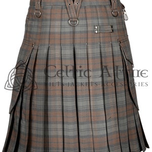 May include: A brown and gray plaid kilt with cargo pockets and a leather strap with metal buckles. The kilt has a Celtic Attire logo on the front.