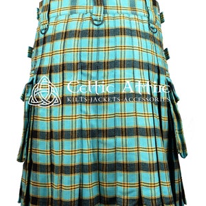Puede incluir: Un kilt de tart&aacute;n azul, amarillo y negro con bolsillos cargo. El kilt est&aacute; plisado y tiene un cintur&oacute;n con hebillas. El texto "Celtic Attire Kilts Jackets Accessories" es visible en el kilt.