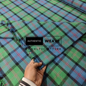 Könnte beinhalten: Nahaufnahme eines grünen, blauen und roten Tartanstoffes mit dem aufgedruckten Text "AUTHENTIC WEAVE CELTIC ATTIRE".