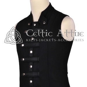 Pode incluir: Um colete preto sem mangas com gola alta e botões prateados. O colete tem tiras pretas e fivelas prateadas na frente. O texto "Celtic Attire" está impresso na frente do colete.