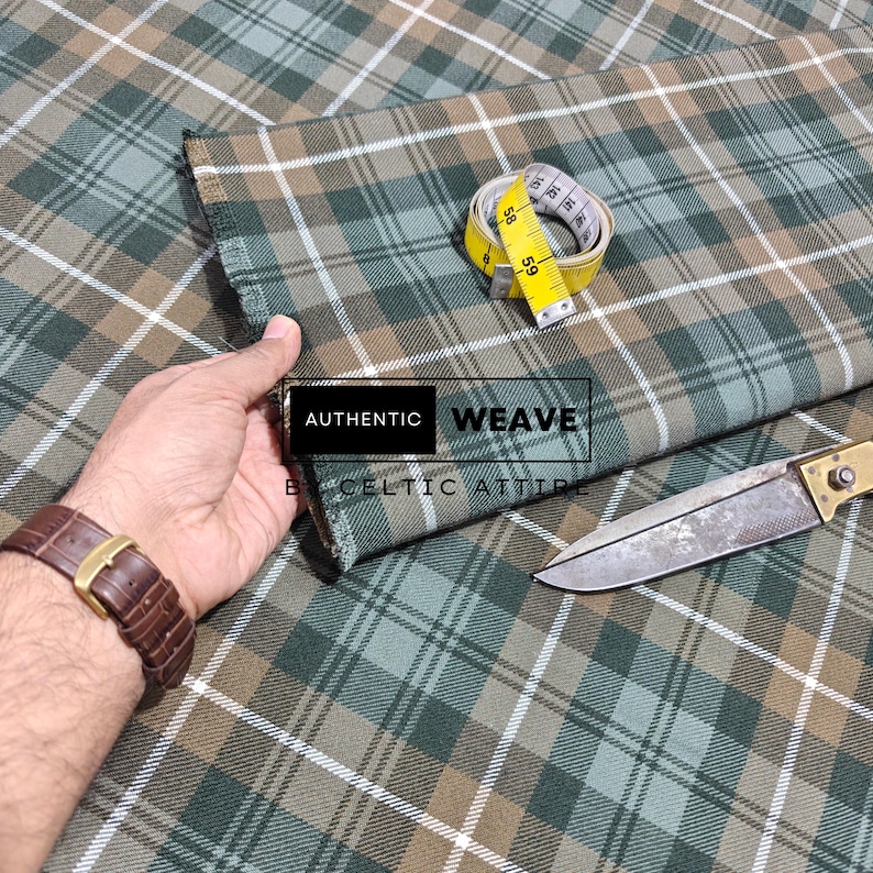 K&ouml;nnte beinhalten: Gr&uuml;n, braun und wei&szlig; karierter Stoff mit einem gelben Ma&szlig;band und einem silbernen und goldenen Messer. Der Stoff tr&auml;gt den Text "AUTHENTIC WEAVE BY CELTIC ATTIRE".
