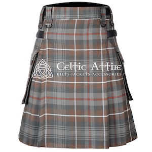 Puede incluir: Un kilt a cuadros grises, marrones y rojos con correas y hebillas de cuero negro. El kilt tiene pliegues y un delantal delantero. El texto "Celtic Attire" y "Kilts-Jackets-Accessories" es visible.