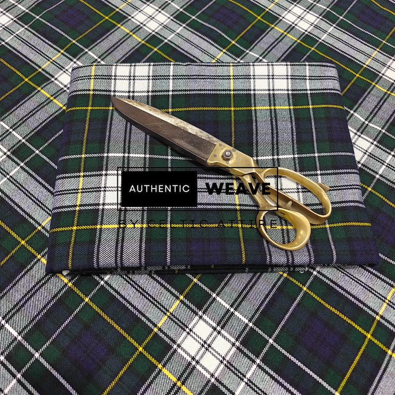 K&ouml;nnte beinhalten: Ein gefaltetes St&uuml;ck gr&uuml;n, marineblau, wei&szlig; und gelb karierter Stoff mit einer Vintage-Goldschere darauf. Die Schere ist ge&ouml;ffnet und der Stoff hat ein klassisches Tartanmuster. Der Text "AUTHENTIC WEAVE" ist sichtbar.