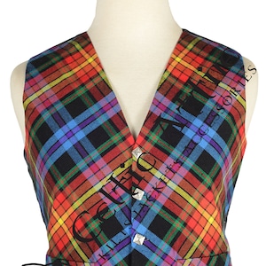 May include: A black vest with a colorful plaid pattern. The vest has a V-neck and is adorned with silver buttons. The vest is made of a woven fabric and has a traditional Scottish tartan design.