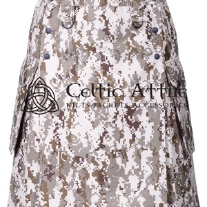 K&ouml;nnte beinhalten: Ein Tarnkilt mit einem wei&szlig;en, braunen und beigefarbenen Muster. Der Kilt hat ein keltisches Knotendesign und den Text "Celtic Attire Kilts Jackets Accessories" auf der Vorderseite.