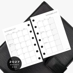 May include: Two white planner pages for November 2027 with black text and grid lines. Each page features a monthly calendar layout with punched holes along the side for binding. The text includes dates, days of the week, and holidays.