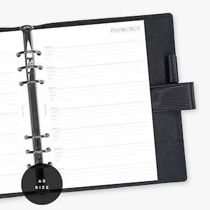 Puede incluir: Carpeta negra tamaño A5 con papel rayado para registrar contraseñas. La palabra "PASSWORDS" está impresa en la parte superior de la página. La carpeta tiene un mecanismo de anillas de metal plateado y una cubierta negra similar al cuero.