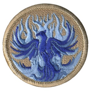 May include: A blue and light blue embroidered patch of a phoenix rising from flames on a tan background.