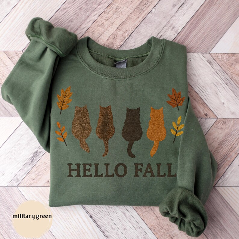 Cozy fall cat sweatshirt with pumpkin patch and autumn vibes.