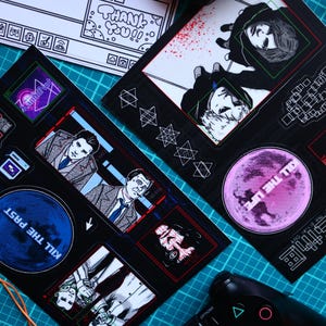 May include: A set of black and white stickers with various designs, including a blue circle with the text "KILL THE PAST", a red circle with the text "FULL THE LIFE", and a stylized illustration of a person with the text "SYNCHRONIZE".