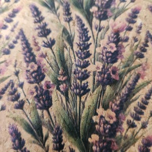 Puede incluir: Primer plano de un diseño floral con ramitas de lavanda en tonos morados y rosas, con hojas verdes, sobre un fondo marrón claro. La imagen presenta un tema botánico, posiblemente para la decoración del hogar o proyectos de manualidades.