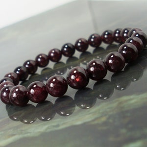 May include: A bracelet made of dark red garnet beads.