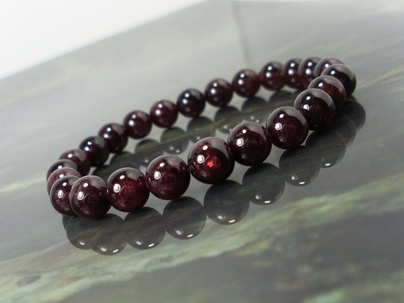 May include: A bracelet made of dark red garnet beads.