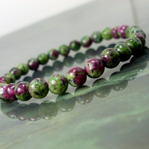 Peut inclure: Un bracelet en pierres précieuses vertes et roses avec des perles rondes. Le bracelet est fait de pierres naturelles et est un choix populaire pour les bijoux.