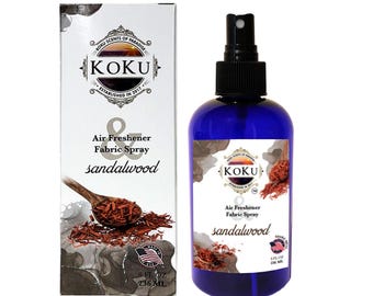 May include: A blue bottle of sandalwood scented air freshener and fabric spray. The bottle is labeled "KOKU Air Freshener & Fabric Spray sandalwood" and has a black spray nozzle. The bottle is 8 fl oz (236 ml).