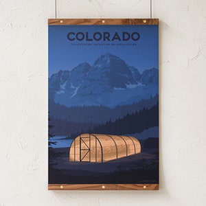May include: A poster featuring a nighttime landscape with mountains, trees, and a greenhouse. The word "COLORADO" is at the top, with the text "ENLIGHTENING THE NATION ON LEGALIZATION" below. The poster is framed in wood.