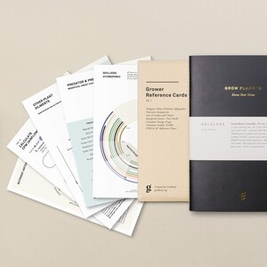 May include: A set of grower reference cards with a black grow planner notebook. The cards feature charts and infographics for calculating airflow, nutrient ratios, and other growing information. The notebook has the text "Grow Planner Know Your Grow" on the cover.