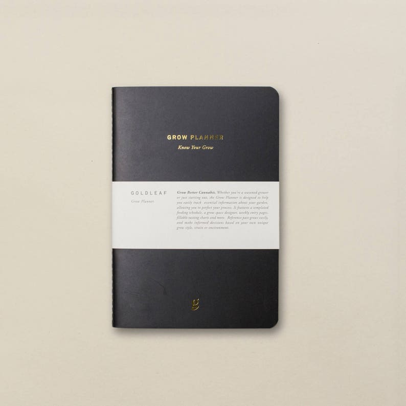 May include: A black, hardcover journal with gold lettering that reads "GROW PLANNER Know Your Grow" and "GOLDLEAF Grow Planner".