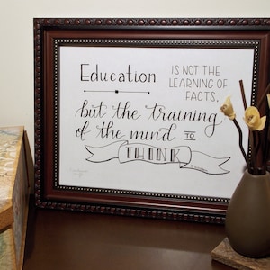 May include: A framed print with a quote about education. The quote reads "Education is not the learning of facts, but the training of the mind to think." - Albert Einstein.