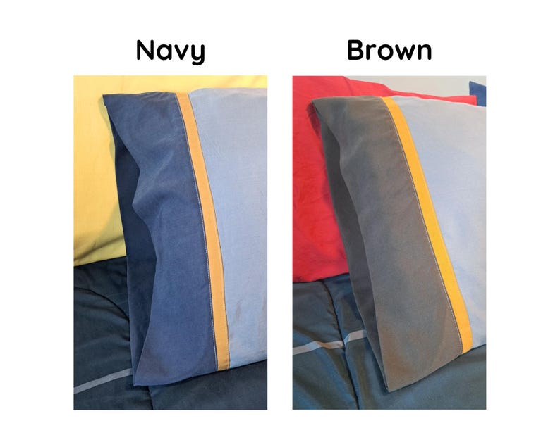 May include: Two rectangular pillowcases are displayed side-by-side. The left pillowcase is navy blue with a light blue panel and a thin orange stripe. The right pillowcase is brown with a light blue panel and a thin orange stripe. Text reads Navy and Brown.