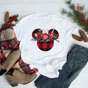 May include: White t-shirt with a red and black buffalo plaid Mickey Mouse head design featuring a floral arrangement in the center.