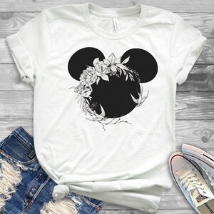 May include: White t-shirt with a black floral Mickey Mouse silhouette design.