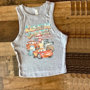 May include: Gray tank top with a graphic of the Cars characters from the movie Cars. The graphic includes the text "Radiator Springs" and features Lightning McQueen, Mater, and other characters.