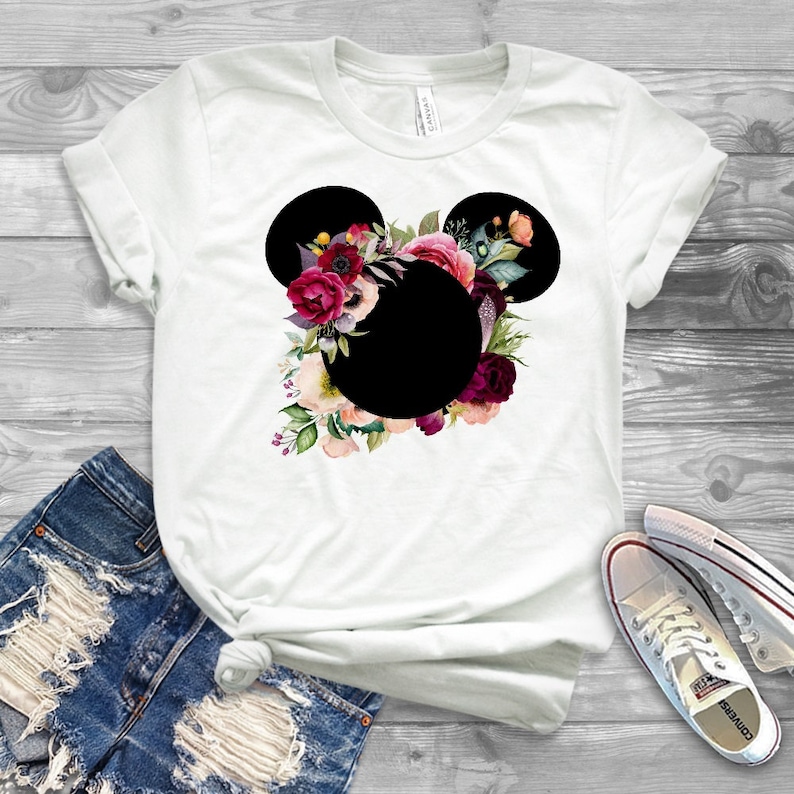 May include: White t-shirt with a black floral Mickey Mouse silhouette. The flowers are pink, red, and purple.