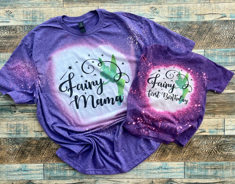 May include: Purple and pink tie-dye t-shirts with a green fairy silhouette and the text "Fairy Mama" and "Fairy first Birthday".