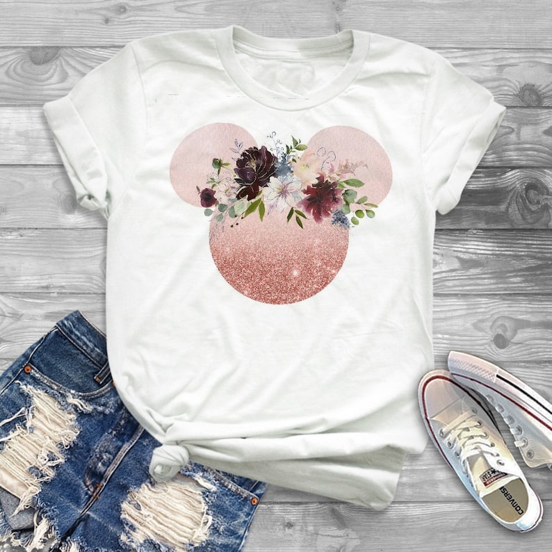 May include: White t-shirt with a pink and gold glitter Mickey Mouse head design featuring a floral arrangement in shades of burgundy, pink, and white.