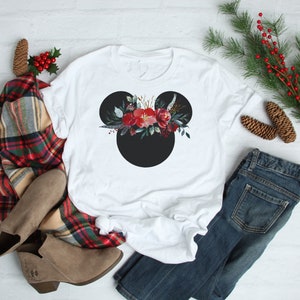 May include: White t-shirt with a black Mickey Mouse silhouette and a red and green floral design on the head.