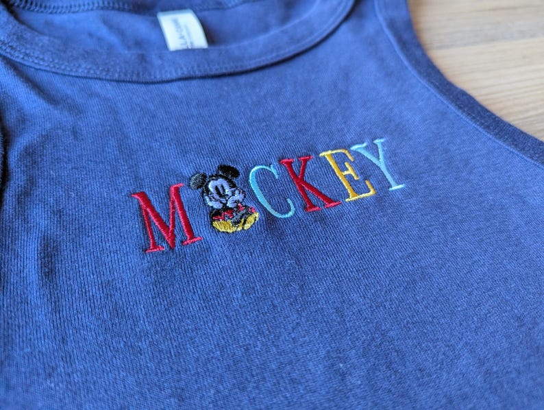 May include: A white ceramic mug with a black handle and the text "But First, Coffee" in a handwritten style. The mug is on a white surface. The mug is 4 inches tall.